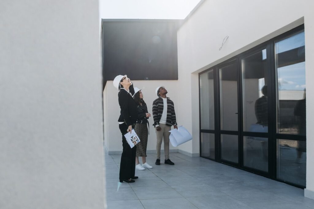pexels-photo-7937732-7937732 Group of real estate agents assessing a modern building during the day.